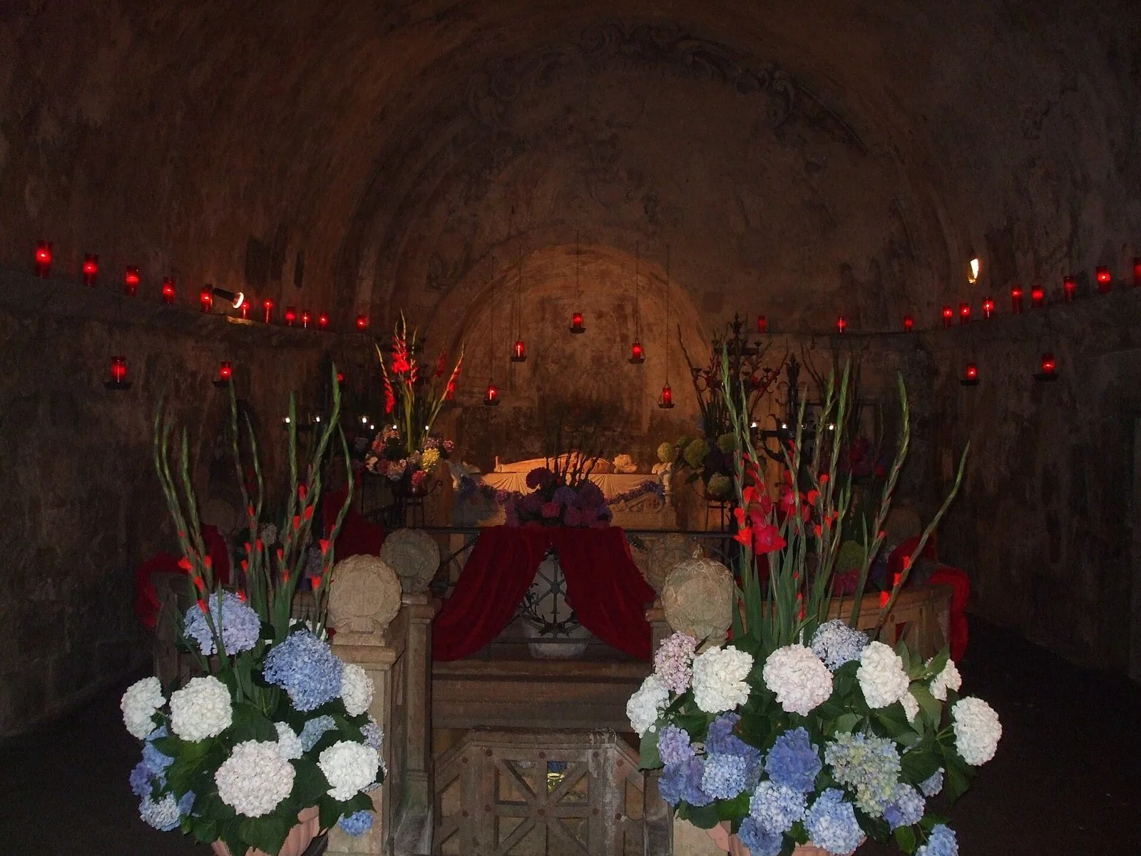 La grotta di Santa Cristina a Bolsena addobbata con ortensie, gladioli e lumini rossi durante la festa della santa