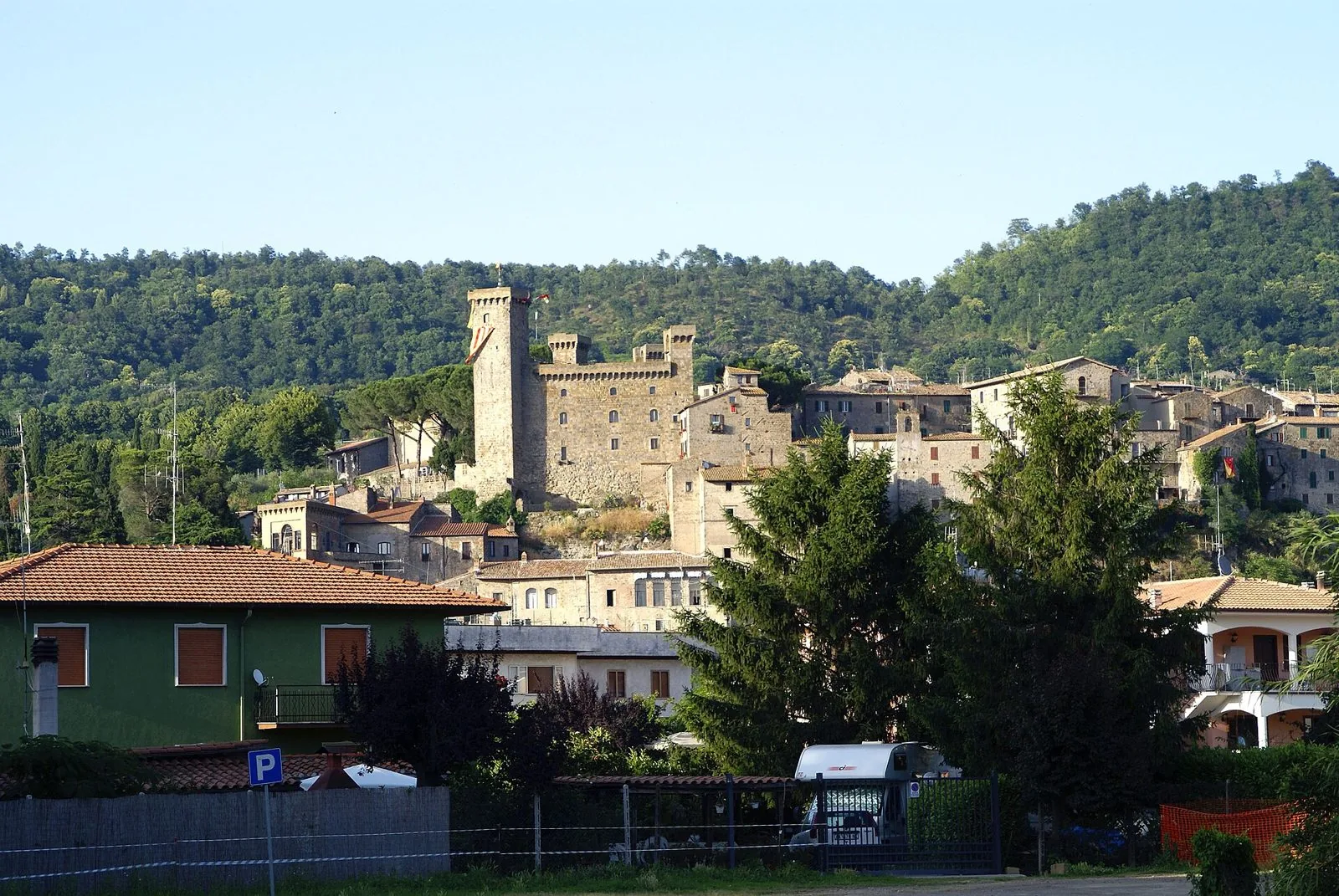 Il centro storico di Bolsena con la Rocca Monaldeschi e le case in pietra sulla collina boscosa